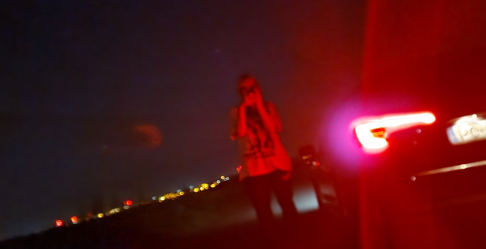 roadside / taillight / city below
